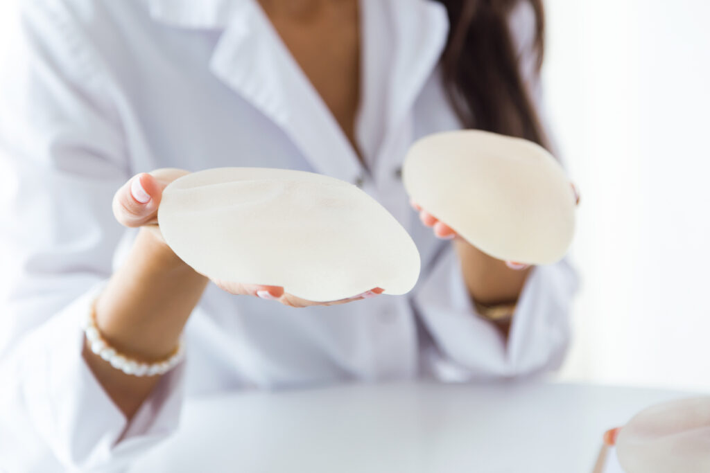 Portrait of female doctor choosing mammary prosthesis in the office.